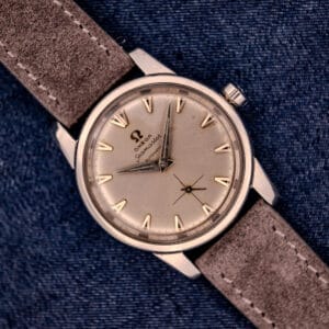 An Omega Automatic Seamaster 2846-2848 Stainless Steel watch with a sunburst dial, stylishly presented on blue denim fabric.