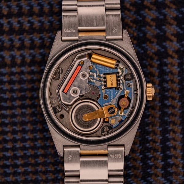 Close-up of the Tudor Prince-Quartz Oysterdate Ref. 9150, showcasing its exposed inner mechanical and electronic components on a metal strap, with a distinctive two-tone blue dial.