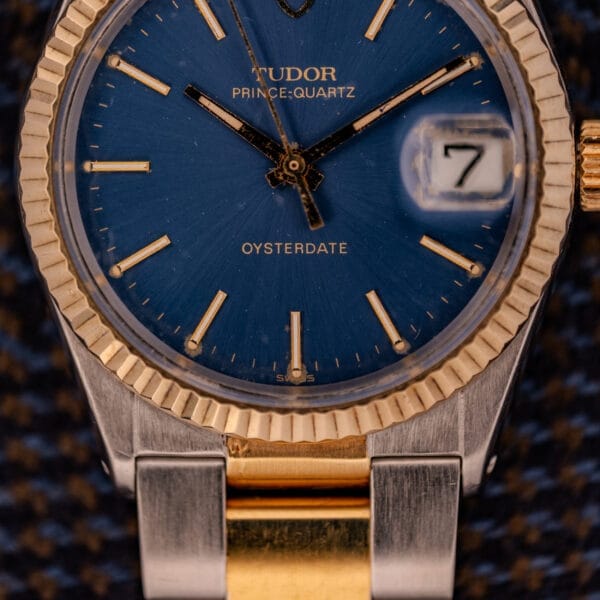 Close-up of the Tudor Prince-Quartz Oysterdate Ref. 9150, highlighting its two-tone blue dial with gold accents and date display set to 7.