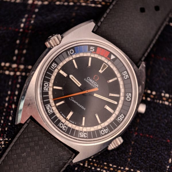 Close-up of an Omega Seamaster Ref. 145.008 Chronostop Regatta Cal. 865 watch with a black strap, shown against a plaid fabric background.