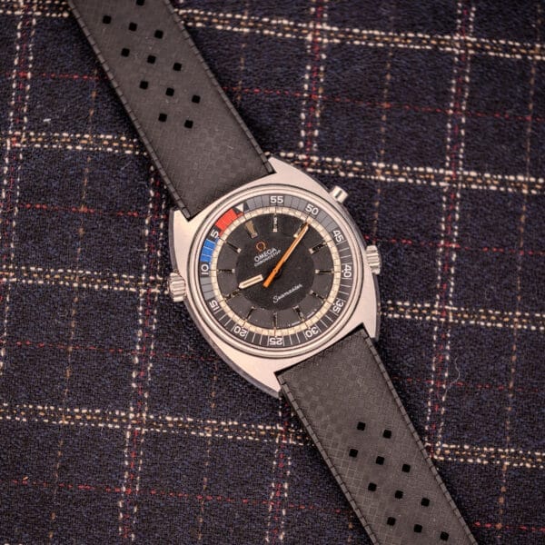 Omega Seamaster Ref. 145.008 Chronostop Regatta Cal. 865 with a black perforated strap, displayed on a plaid fabric background.