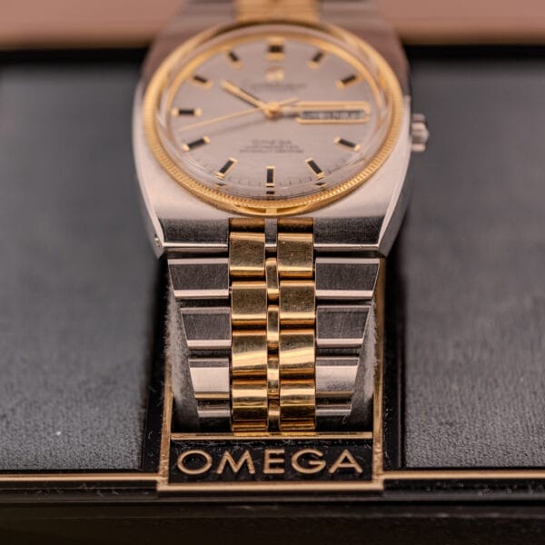 The Omega Constellation Chronometer Ref. 168.045 Day/Date Full Set is a two-tone wristwatch with a gold and silver bracelet, chronometer precision, and is displayed on a stand with the Omega logo.