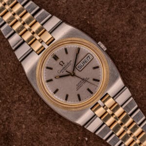 Omega Constellation Chronometer Ref. 168.045 Day/Date Full Set with gold and silver bracelet, featured on a brown background.