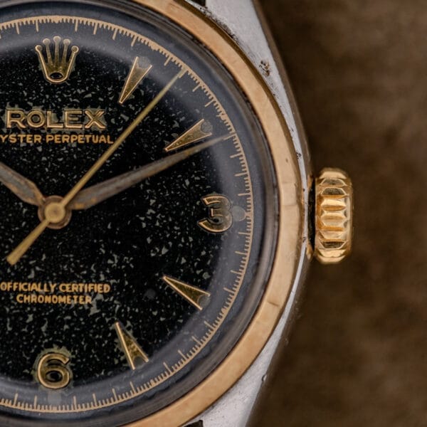 Close-up of the Rolex Oyster Perpetual "Big Bubble Back" Ref. 6107 Black Dial, featuring gold accents and vintage design details.