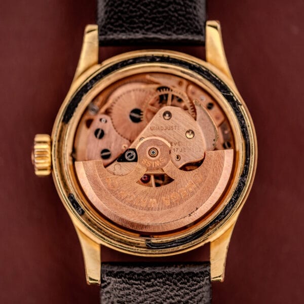 Close-up of the Omega Ladymatic Sunburst Dial Ref. MD 566.021, showcasing its exposed Cal. 680 mechanical movement and gears, paired with a black leather strap.