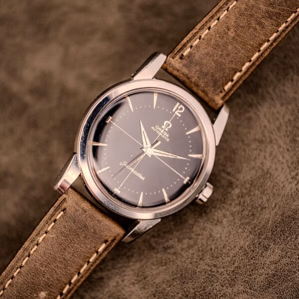 Front-angled view of the Omega Seamaster Ref. 2848 with speckled black dial and aged dauphine hands paired with olive leather