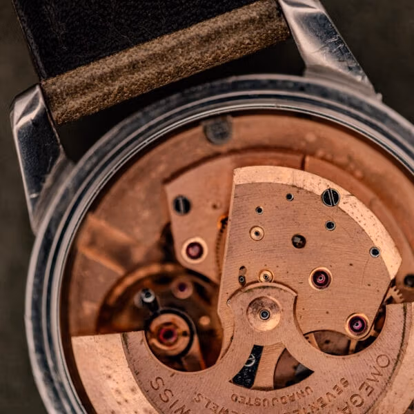 Macro close-up of the Omega caliber 500 movement in the Seamaster Ref. 2848 with copper bridges, ruby jewels, and signed Omega rotor