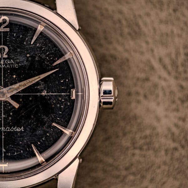 Close-up of an Omega Automatic Seamaster Ref. 2848 Black Dial Cal. 500 wristwatch with a scratched black dial and silver casing.