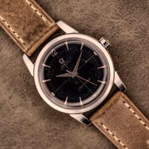 An Omega Automatic Seamaster Ref. 2848 with a black dial and brown leather strap, Cal. 500, displayed on a suede surface.