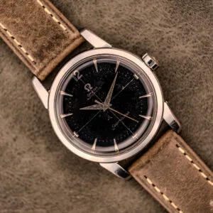 An Omega Automatic Seamaster Ref. 2848 with a black dial and brown leather strap, Cal. 500, displayed on a suede surface.