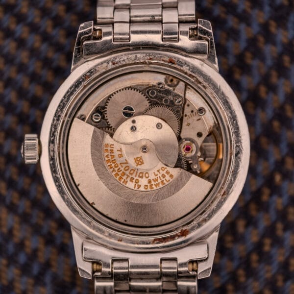 Close-up of the Zodiac Aerospace GMT Ref. 752-934’s exposed mechanical movement with gears, black dial, chrome bezel, and "Seventeen 17 Jewels"—a classic detail from the renowned Zodiac collection.