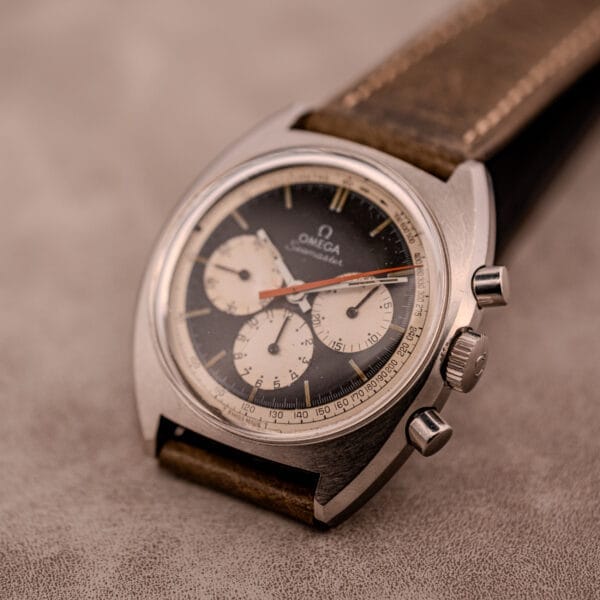 An Omega Seamaster Chronograph Ref. 145.016 with a Reverse Panda Dial and brown leather strap rests elegantly on a textured surface.