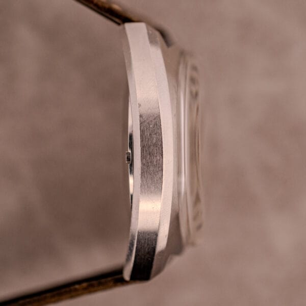 Side view of the Omega Seamaster Chronograph Ref. 145.016 Reverse Panda Dial, showcasing its textured silver case against a soft, neutral background.