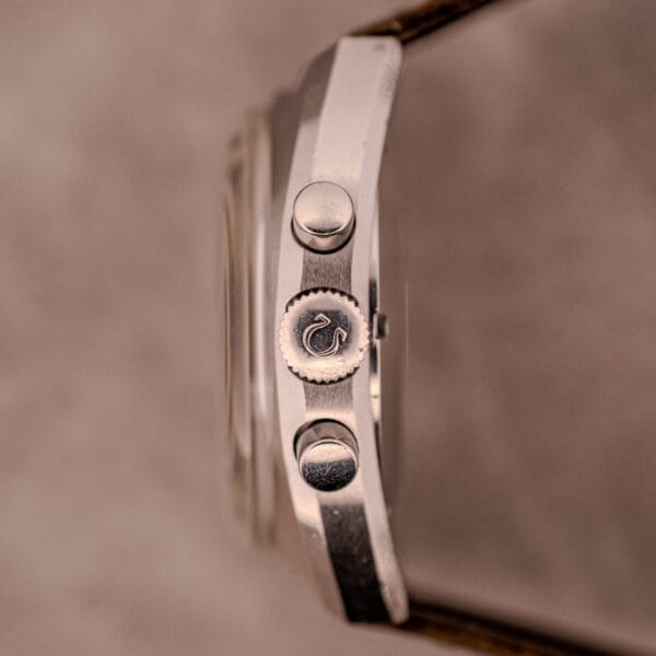 Close-up side view of the Omega Seamaster Chronograph Ref. 145.016 Reverse Panda Dial, showcasing two buttons and a crown featuring a serpent logo.