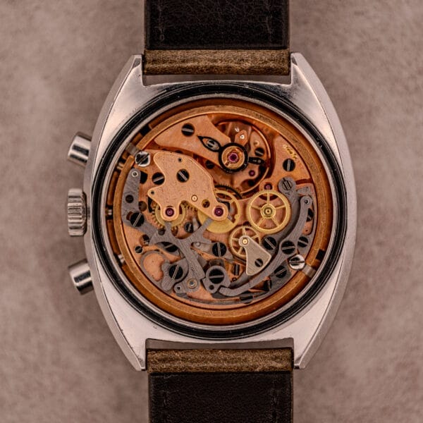 Close-up of a vintage mechanical watch with visible gears and intricate workings, echoing the craftsmanship of the Omega Seamaster Chronograph Ref. 145.016 Reverse Panda Dial.