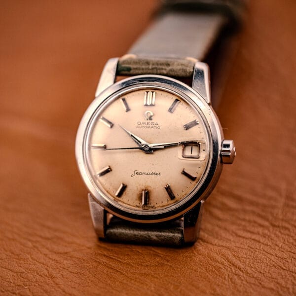 An Omega Automatic Seamaster Ref. 2849 Stainless Steel Chunky Lugs wristwatch rests elegantly on a brown leather surface.