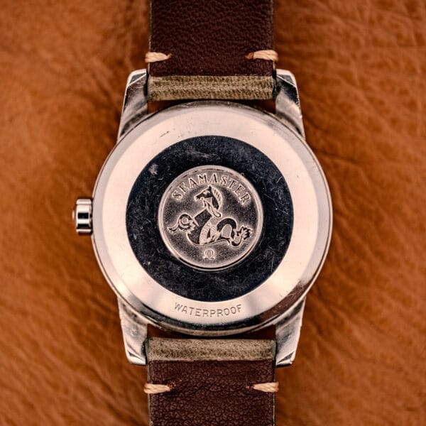 Close-up of the back of an Omega Automatic Seamaster Ref. 2849 with chunky lugs, stainless steel case, seahorse logo, and leather strap.