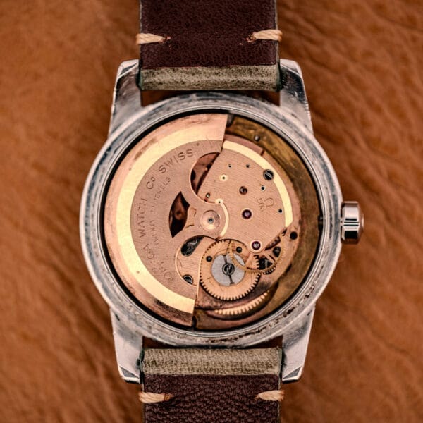 Close-up of an Omega Automatic Seamaster Ref. 2849 Stainless Steel Chunky Lugs, showcasing its exposed mechanical movement with visible gears and Swiss engraving, set in a stainless steel case and complemented by a leather strap.