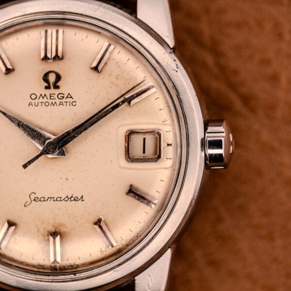 Close-up of an Omega Automatic Seamaster Ref. 2849 with chunky lugs, featuring a cream dial, stainless steel case, and date window showing the number 1.