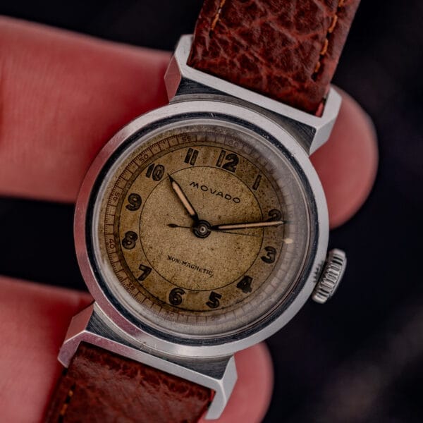 Close-up of a vintage Movado "Acvatic" FB Case Sector Dial Ref. 11730 Cal. 150MN wristwatch with a brown leather strap and an aged sector dial.