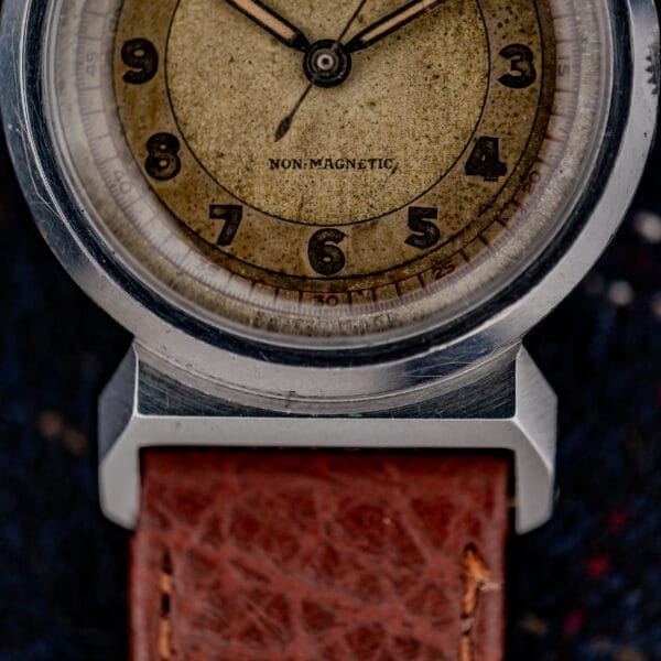 Close-up of a vintage Movado "Acvatic" FB Case Ref. 11730 wristwatch featuring a brown leather strap, aged sector dial marked NON-MAGNETIC, and powered by the Cal. 150MN movement.