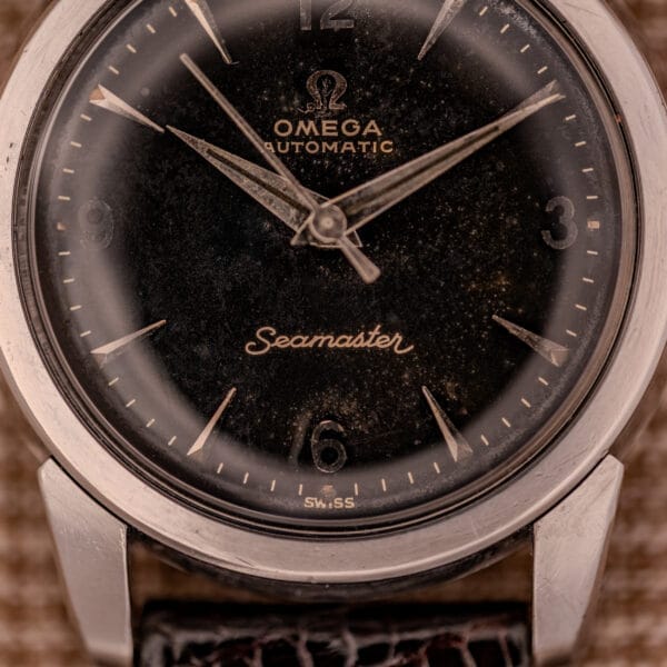 Close-up of a 1956 Omega Seamaster Automatic Ref. 2828-6 SC Cal. 470, featuring a black dial, silver hour markers, and classic stainless steel case.