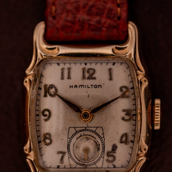 Hamilton Lawton Art Deco wristwatch featuring a gold filled case, manual wind Cal. 747 movement, square face, and brown leather strap set to 10:10.