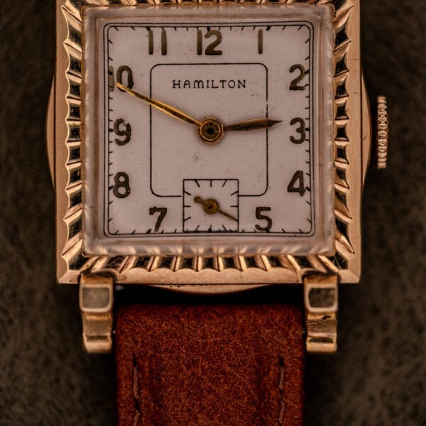 Hamilton Art Deco Square Gold Filled Case Manual Wind Cal. 987-F wristwatch with white dial, brown leather strap, and ornate bezel.