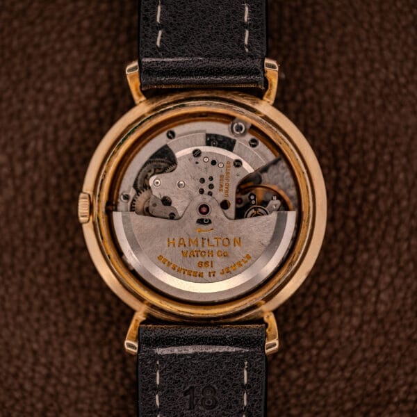 Close-up of the Hamilton K-454 Sputnik Automatic Cal. 661's exposed mechanical movement, featuring a gold filled case and black leather strap.