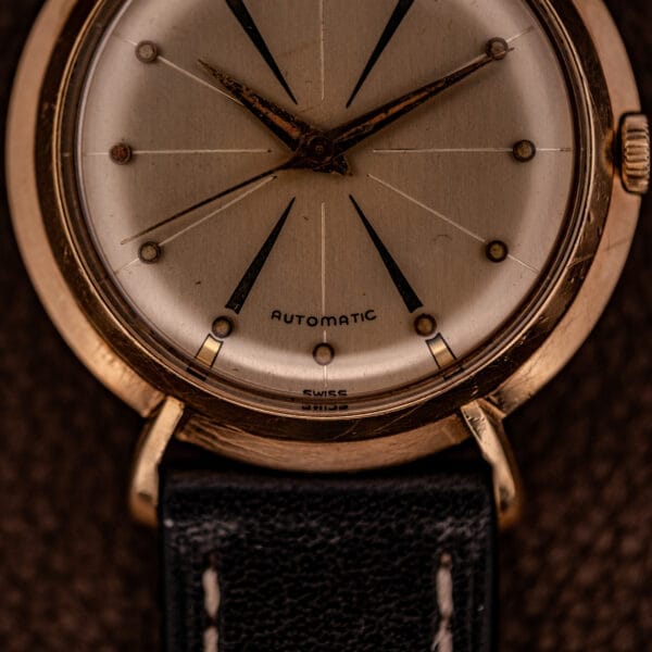 Close-up of a Hamilton K-454 Sputnik Automatic Cal. 661 wristwatch featuring a gold filled case, black leather strap, and “Automatic” on the dial.