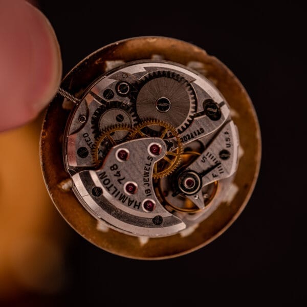 Close-up of intricate watch gears and mechanisms labeled Hamilton 748, 17 Jewels, USA—showcasing the manual wind craftsmanship of the Hamilton Rodney Sector Dial with a 10k gold filled case.