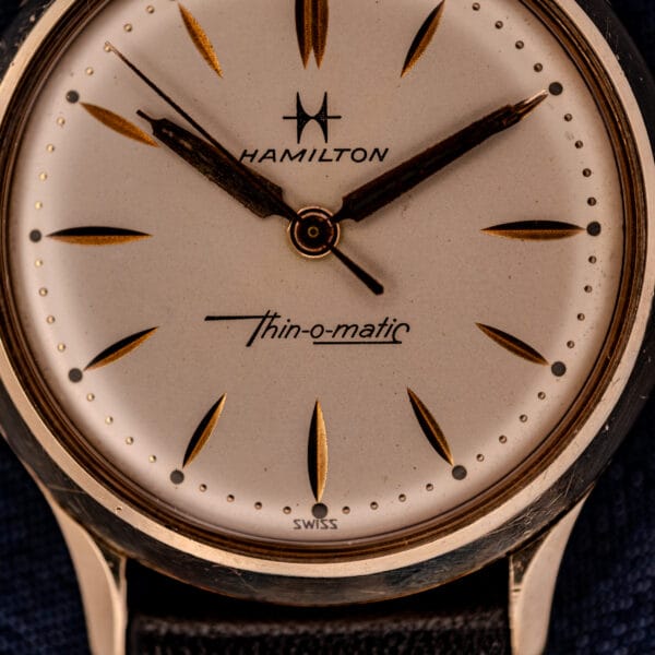 Close-up of a 1962 Hamilton Thin-o-Matic Cal. 663 wristwatch at 2:11, featuring gold markers, black hands, and a classic 10K Gold Filled case.