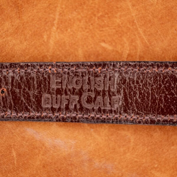 Close-up of a brown leather strap embossed with ENGLISH BUFF CALF, paired with the elegant 1966 Hamilton Thin-o-matic Cal. 668 10K Gold Filled watch.