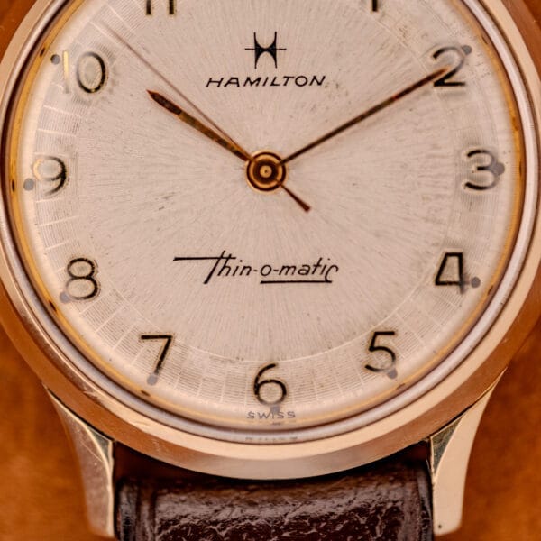 Close-up of a 1966 Hamilton Thin-o-matic Cal. 668 with a 10K Gold Filled case, gold hands, tan dial, and brown leather strap.