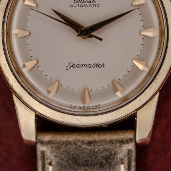 Close-up of an Omega Automatic Seamaster Ref. 2846-2848 "Deluxe" with gold markers, a gold capped case, and a leather strap.
