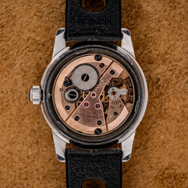 A close-up of the 1967 Enicar Seapearl 600 Sherpa Ref. 100/120 Cal. 1010 Stainless Steel reveals its vintage exposed mechanical movement, with visible gears and metal parts highlighting its intricate workings.