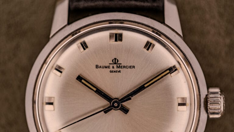 Close-up of a Baume & Mercier Genève wristwatch with a silver dial and black leather strap, showcasing the timeless elegance of Baume Mercier craftsmanship.