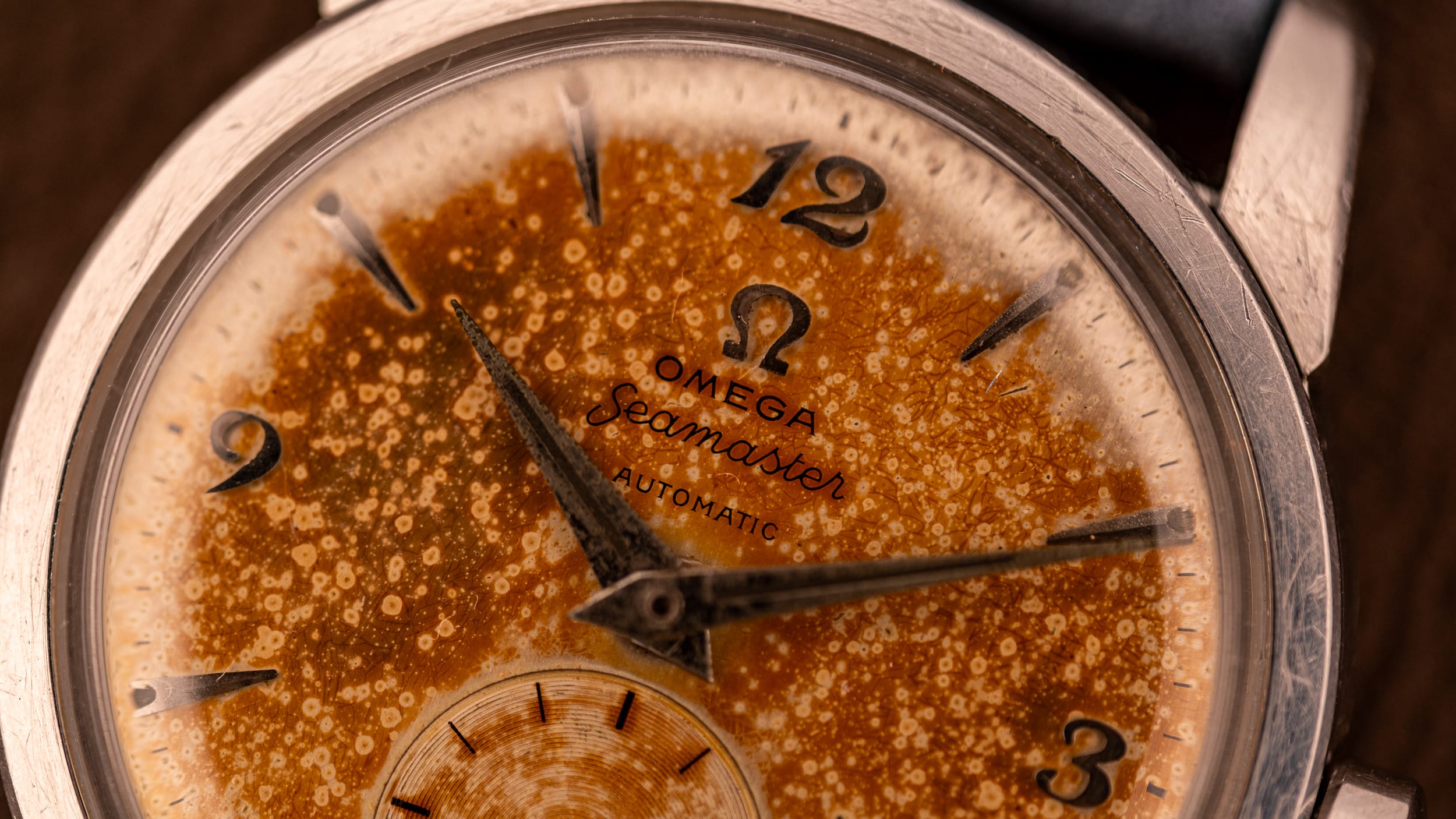 Close-up of a vintage Omega Seamaster, showcasing a heavily patinated and spotted tropical dial—an iconic choice for collectors of vintage watches.