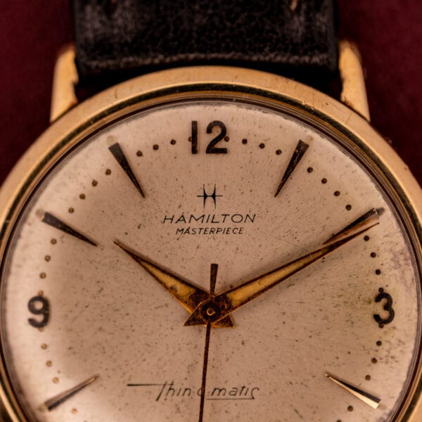 Close-up of a Hamilton Thin-O-Matic 10k Gold Filled Case Automatic wristwatch with a black leather strap.