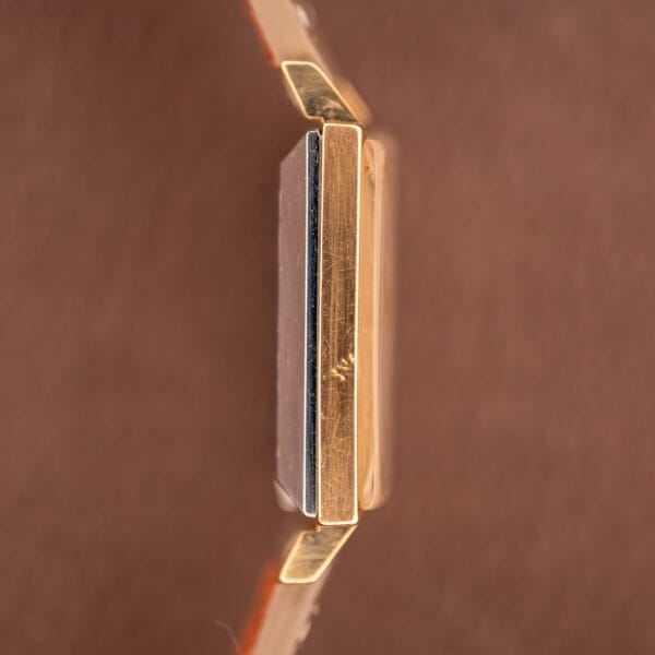 Side view of the Zodiac Ref. 523-007 Square Case Manual Wind Cal. 52 gold watch set against a blurred brown background.