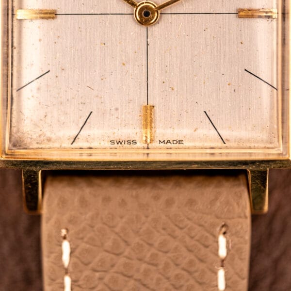 Close-up of a Zodiac Ref. 523-007 Square Case Manual Wind Cal. 52 watch face with gold details and a textured beige leather strap.