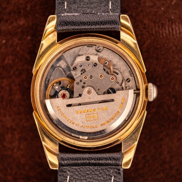 Close-up of a vintage Zodiac Rotographic Ref. 656 with Tropic Dial, automatic Cal. 1381 movement, visible gears and engravings, gold case, and black strap.