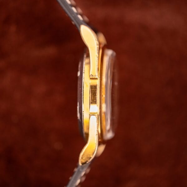 Side view of the Zodiac Rotographic Ref. 656 Tropic Dial Automatic Cal. 1381 gold wristwatch with leather strap, displayed against a soft brown background.