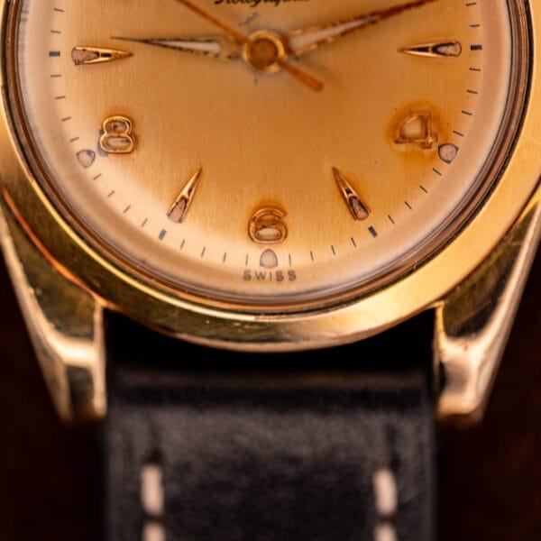 Close-up of a Zodiac Rotographic Ref. 656 Tropic Dial Automatic Cal. 1381 wristwatch, featuring vintage gold case, black leather strap, and Swiss marking at 6 o'clock.