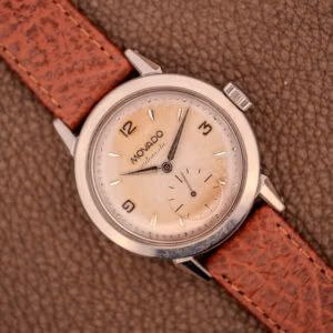 Movado Automatic Bumper ref. 18451 hero shot, warm cream dial with butterscotch patina, Francois Borgel steel case, rust-red leather strap.