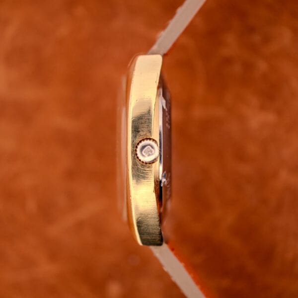 Side profile of the Girard Perregaux Gyromatic 9276 HA showing the gold-toned case, brushed grain on the side, and the GP-signed crown.