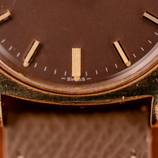 Lower dial macro of the Girard Perregaux Gyromatic showing the printed SWISS marker at six and applied gold baton marker detail.