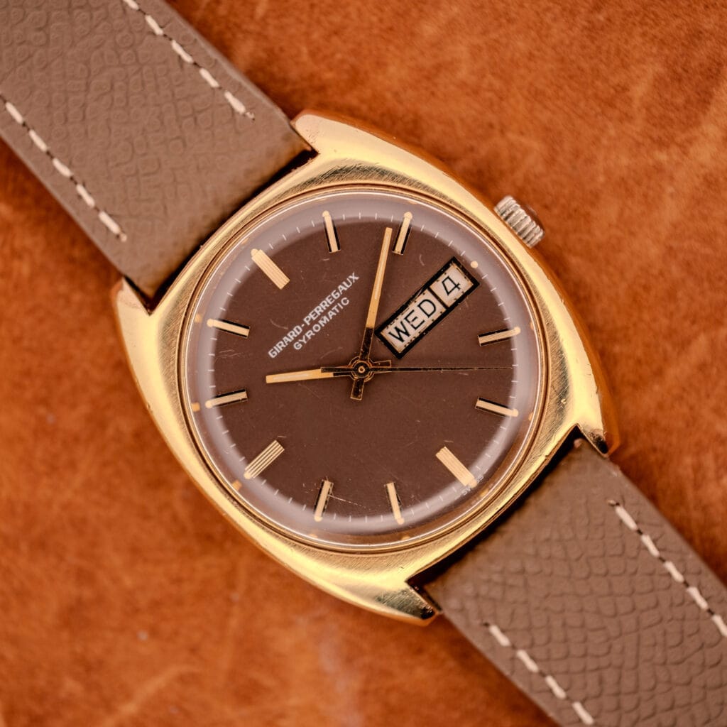 Girard Perregaux Gyromatic Ref. 9276 HA front view, gold electroplate cushion case and chocolate brown dial with day/date at three.