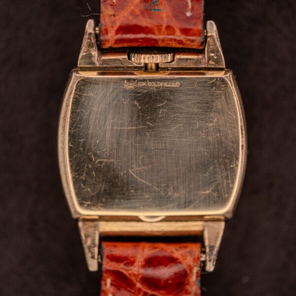 Gruen "Top Crown" 10K Gold Filled 17 Jewels Ref. 400-298 c.1940s watch with a rectangular case, worn and scratched back, and brown leather strap.