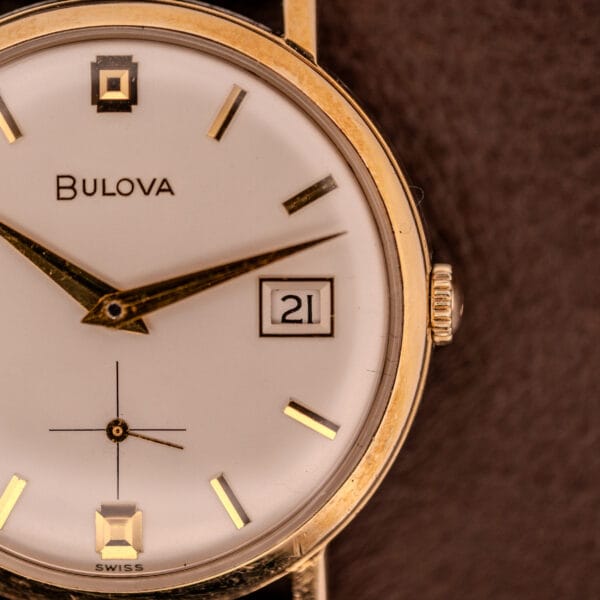 Close-up of a Bulova Manual Wind Date 10K RGP Cal. 11ALD c.1968 wristwatch, showing the time at 8:22 and the date as the 21st.